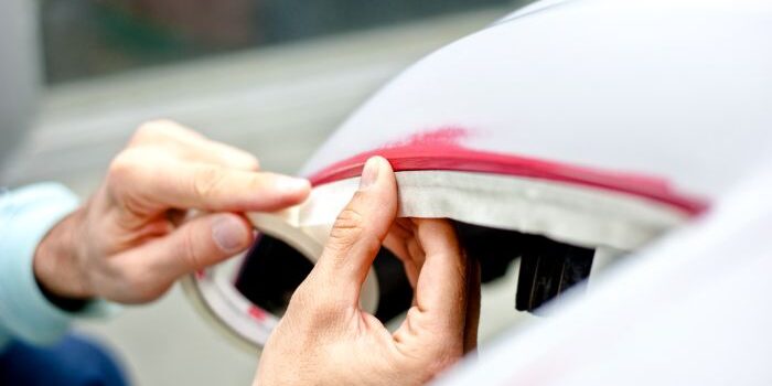 mechanic-preparing-a-car-for-painting-by-protectin-PRA39MB