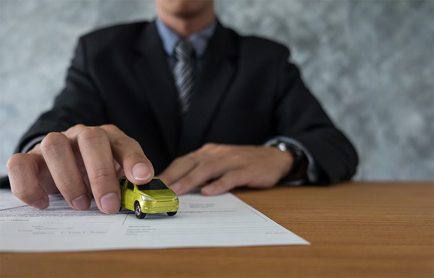 Coche en miniatura sobre documentos de la nueva normativa de vehículos históricos