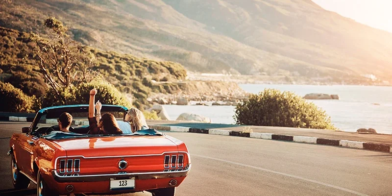 Pebble Beach Motoring Classic 2025_ el viaje por carretera más exclusivo del mundo del motor clásico Pebble Beach Motoring Classic 2025 - Coche clásico en carretera con playa de fondo