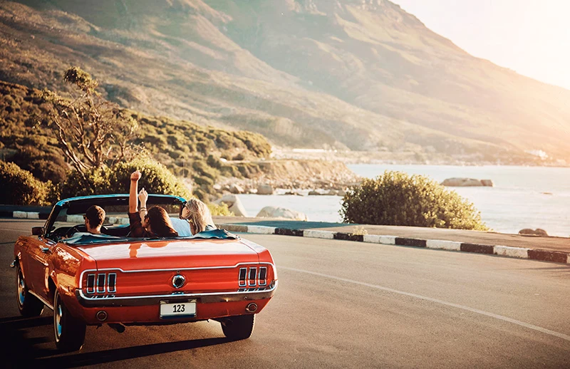 Pebble Beach Motoring Classic 2025 - Coche clásico en carretera con playa de fondo